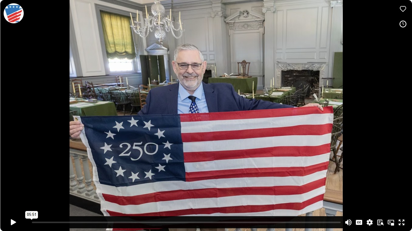 screen shot of vimeo link. Sen. Dush standing in an elegant room with an american flag with the numbers 250 in the blue area, surrounded by a circle of white stars.